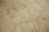Distressed texture and geometric guls in faded teal and cream on vintage Ersari rug.