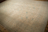 Faded, worn texture of the Ersari rug's geometric beige and dusty teal border.