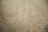 Distressed texture of a vintage Ersari carpet, showing faded beige and blue geometric gul patterns.