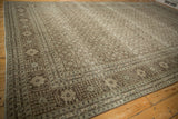 Decorative corner of a distressed Tabriz rug, Herati pattern in charcoal, ivory hues.
