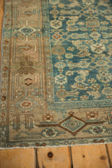 Distressed main border with Samovar motif next to the worn blue floral field of a vintage Kurdish Hamadan rug.