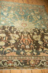 Close view of a distressed Hamadan rug's starburst medallion centered on a heavily abrashed ground.