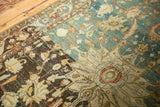 Starburst medallion detail on a vintage rug with heavily abrashed blue and brown fields.