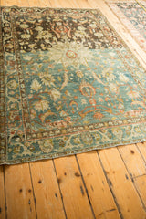 Angled view of a distressed Hamadan rug's dramatic color shift from dark brown to faded blue.