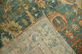 A folded corner of a vintage Hamadan rug showing the hand-knotted weave and side cord.