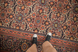 Antique Joshegan carpet's allover scrolled floral field with reciprocating pawn motif border.