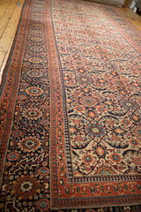 Close-up of antique Joshegan carpet's ivory field, madder red border, and reciprocating pawn motif.