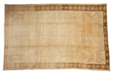 Vintage distressed Kars carpet with a neutral open field, geometric corner spandrels, and snowflake border.