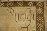 Close-up on the geometric scrolled tendrils and snowflake border of a vintage Kars carpet.