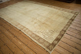Corner detail of a vintage Kars carpet showing geometric spandrels and a snowflake border in neutral tones.