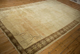 Vintage Turkish Kars carpet viewed at an angle, showing its distressed open field and geometric borders.