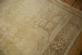 Geometric scrolled tendrils in a corner spandrel on a vintage distressed Kars carpet.