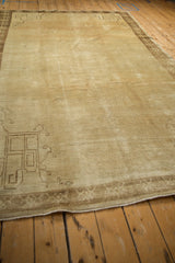 Angled view across the distressed pile of a vintage Kars carpet showing a geometric corner detail.