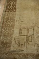 Corner spandrel detail and geometric snowflake border on a distressed Kars carpet in neutral tones.