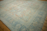 Distressed Mahal carpet with abrashed field, faded floral palmettes, blush and blue border.