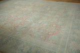 Distressed Mahal carpet's abrashed field, showing faded floral palmettes in muted blush and blue.