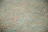 Worn texture of a distressed Persian Mahal rug with soft palmettes in blush, blue, and beige.
