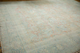Distressed vintage Mahal carpet texture with faded blush and dusty blue floral motifs.