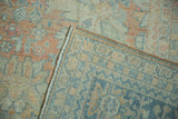 Distressed Mahal carpet corner showing worn pile in pale colors and tight blue woven foundation.