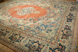 Wide navy border of a distressed Arak carpet with terracotta and sand stylized floral designs.