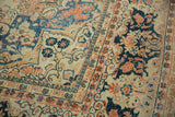 Close-up of mostly even wear on a vintage Arak carpet with terracotta and navy blue floral designs.