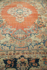 Low-angle view of worn knot heads on the abrashed terracotta field of a vintage Arak carpet.