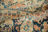 Draped view of the vintage Arak carpet showing the low, textured pile with navy and terracotta florals.