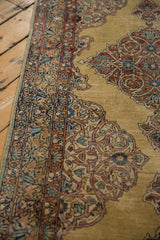 Angled view of the Persian rug runner's intricate border with scrolling arabesques and low pile texture.