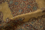 A folded view showing the even wear and intricate spiraled arabesques on a Kerman rug runner.
