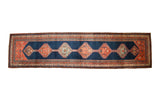 Antique Bijar runner with a column of serrated hexagonal medallions on an abrashed navy blue field.