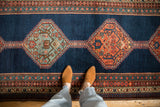 A view of the antique Bijar runner's serrated hexagonal medallions and reciprocating pawn design border.