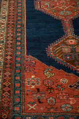 Antique Bijar's pawn motif border and serrated red medallion against a deep navy blue hand-knotted pile.