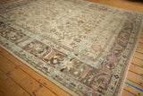 Distressed Lilihan carpet close-up showing worn floral arabesque border in faded beige and terracotta.