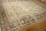 Corner of distressed Lilihan carpet showing dark Herati arabesque border and faded magenta tones.