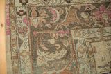 Distressed Lilihan carpet close-up, showing worn pile, arabesque motifs, and faded magenta.