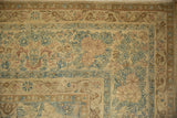 Detailed corner of a distressed Kerman carpet with low pile and a floral cloud-band border.