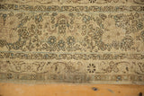 Visible stain on the corner of the distressed Kerman rug, detailing its time-softened patina.