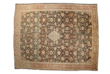 A vintage distressed Persian Mahal carpet with a central ivory medallion and floral palmettes over a charcoal brown field.