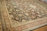 Angled view of a distressed Mahal's worn pile and Herati-like border in charcoal and ruby.