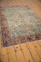 Distressed raspberry red border, weeping willow trees, and ocean green forest field on this Tabriz rug.