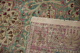 Distressed Tabriz rug close-up; worn ocean green, ivory, and raspberry pile showing foundation weave and selvage.