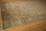 Angled perspective of a vintage Mehrivan carpet with an allover pattern in beige, brown, and slate blue.