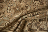 A folded view of the distressed Mehrivan carpet's low, textured pile and geometric pattern.