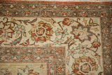 Corner of distressed Kashan rug, beige field, terracotta palmettes, coffee brown floral border.