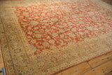 Distressed Kashan carpet detail: faded cherry red field with scrolling palmettes, bordered by ivory floral vines.