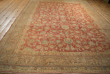 Distressed texture of faded cherry red vintage Kashan rug, with blue floral border detail.