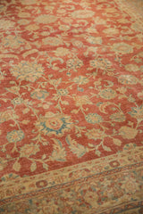 Distressed vintage Kashan carpet with faded cherry red, ivory, and blue floral motifs, showing light wear.