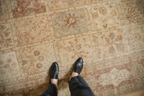 Distressed vintage Tabriz carpet featuring multi-panel Gardens of Paradise design in ivory, rust, and beige.