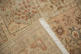 Distressed vintage Tabriz rug revealing faded floral patterns, muted tones, and hand-knotted back.
