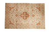 Vintage distressed Persian Tabriz rug with a terracotta medallion, ivory field, and sprawling floral vines.